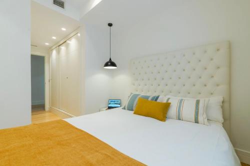 a bedroom with a white bed with a large headboard at INMalaga Luxury Penthouse Nueva 3 in Málaga