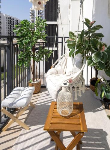 a hammock on a balcony with potted plants at The Surfer's Yas 2BR plus Study Apartment, Full canal & pool view, Theme Parks Yas in Yas Island