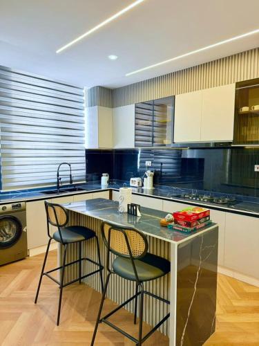 una cocina con una isla con 2 sillas y una barra en The Urbanshortlet, en Moba