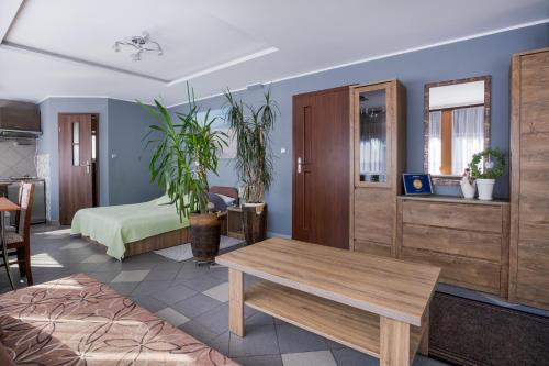 ein Zimmer mit einem Bett und einem Holztisch in der Unterkunft U Derca in Gnieżdżewo