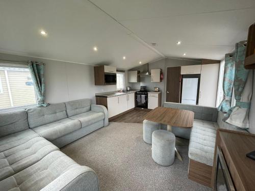 ein Wohnzimmer mit Sofa und Tisch in der Unterkunft 3 Bed Presthaven in Talacre