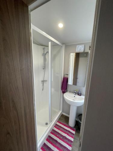 a bathroom with a shower and a sink and a toilet at 3 Bed Presthaven in Talacre