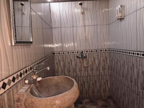 a bathroom with a large tub in the corner at D'Tebe House Kelating in Tabanan