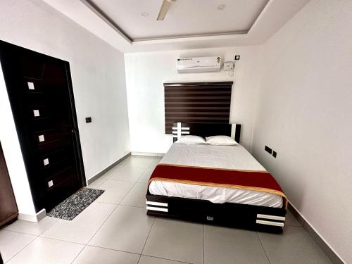 a bedroom with a bed in a white room at Cloud Lacasa in Athirappilly