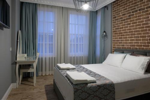 1 dormitorio con 1 cama, escritorio y ventanas en Luna Hotel Kaleiçi en Antalya