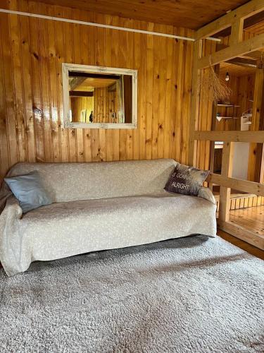 a couch in a wooden room with a window at Те Село in Velyka Volosyanka