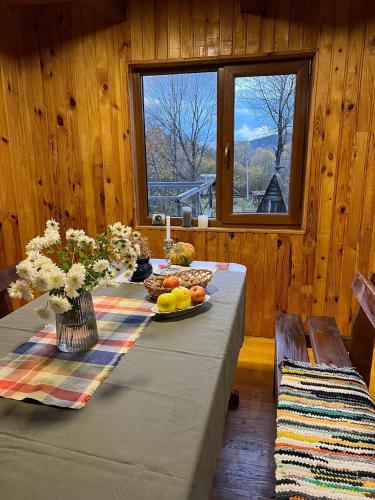 a table with a plate of fruit and flowers on it at Те Село in Velyka Volosyanka