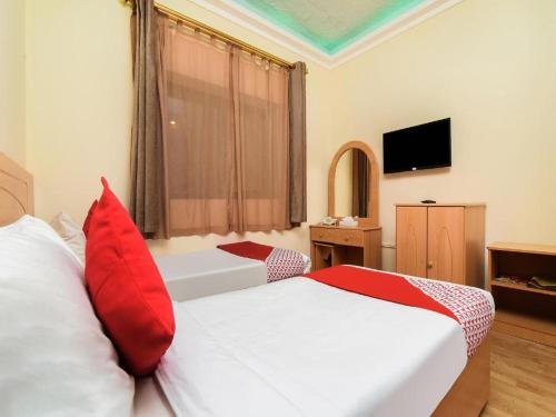 a hotel room with two beds with red pillows at Sama Hotel in Sharjah