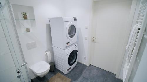 a washing machine in a bathroom with a toilet at Boho Chic in Germering