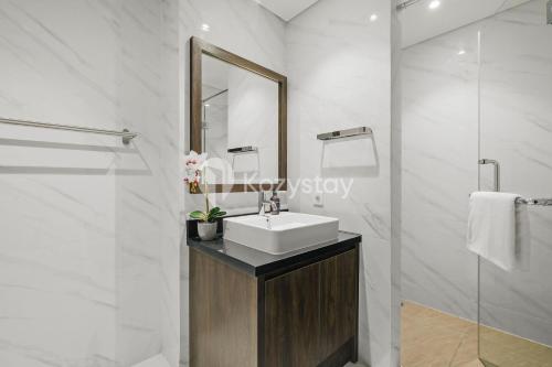 a white bathroom with a sink and a mirror at Sorven by Kozystay - BSD in Samporo