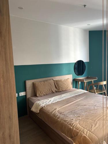 a bedroom with a bed with a blue accent wall at The Sóng Homestay Vibes by the Sea in Vung Tau