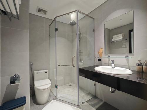 a bathroom with a shower and a toilet and a sink at Minerva Aparthotel Hanoi in Hanoi