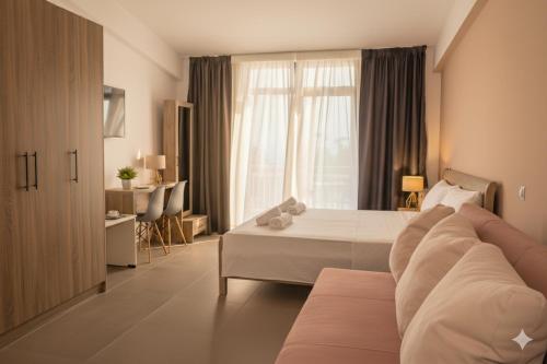 a hotel room with a bed and a couch at Elegant Dream Suites in Ayia anna