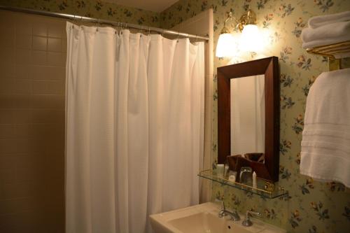 a bathroom with a white shower curtain and a sink at Bluff View Inn in Chattanooga