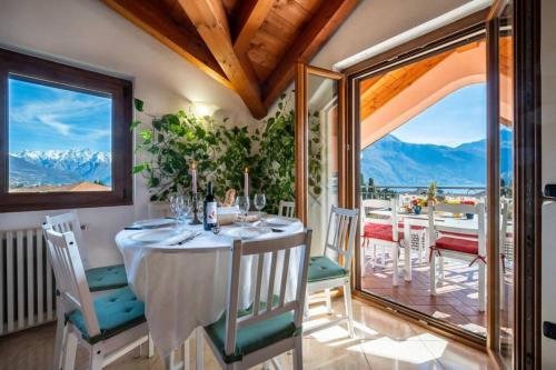 - une salle à manger avec une table et une vue sur les montagnes dans l'établissement Art Music House Lake Como Beach 5 minutes walk, à Dongo