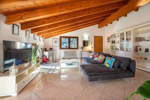 a living room with a couch and a tv at Art Music House Lake Como Beach 5 minutes walk in Dongo