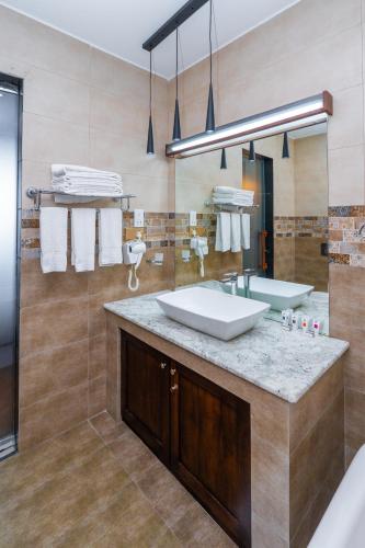 a bathroom with a sink and a mirror and a tub at Dutch Gate Bentota in Bentota