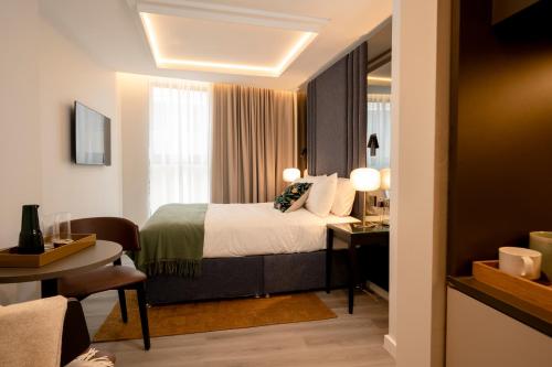 a hotel room with a bed and a desk and a window at The Hobson Cambridge by Adina in Cambridge