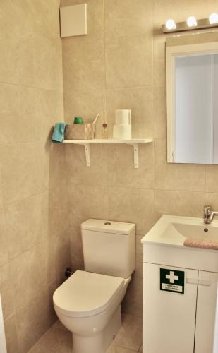 a bathroom with a toilet and a sink at Casa Bem-Vindo in Olhão