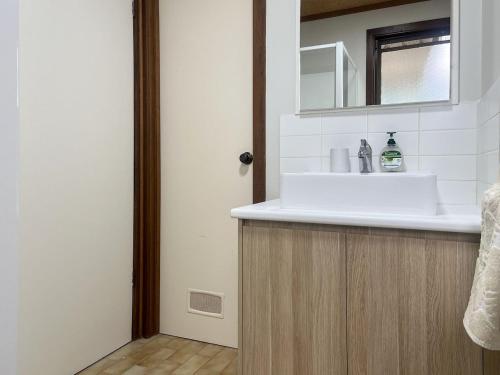 マラクータにあるUnit 11, 6-8 Buckland Drive, Mallacootaの洗面台と鏡のあるバスルーム