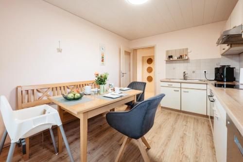 a kitchen and dining room with a wooden table and chairs at Ferienhaus zur Weinlaube in Thurmansbang
