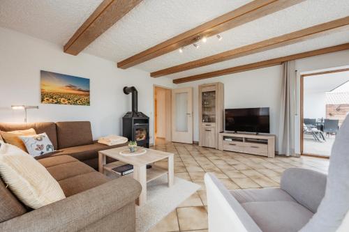 a living room with a couch and a tv at Ferienhaus zur Weinlaube in Thurmansbang