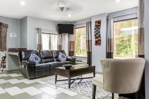 ein Wohnzimmer mit einem Ledersofa und einem Stuhl in der Unterkunft Quality Inn Stockbridge Atlanta South in Stockbridge