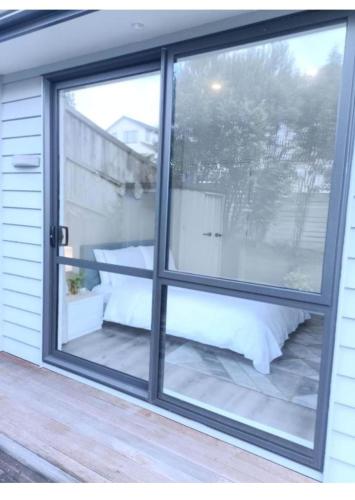 a window with a view of a patio at Long Bay Breeze Ensuite in Auckland
