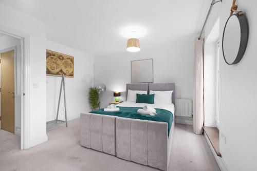 a bedroom with a large bed with green sheets at Foxherne 6BDR 3BA Serviced House with Parking - Slough By 360Stays in Slough