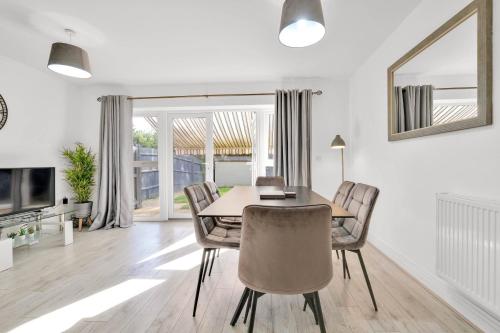 a dining room with a table and chairs at Foxherne 6BDR 3BA Serviced House with Parking - Slough By 360Stays in Slough
