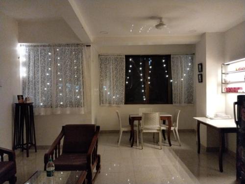 a living room with a table and chairs and a window at Cinnamon House in Pune