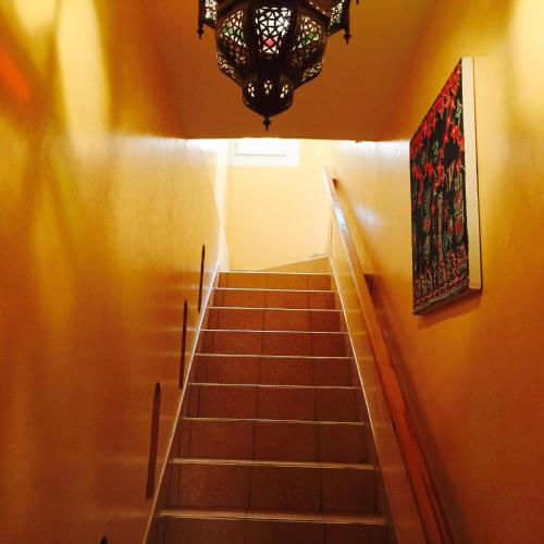 a stairway with a chandelier and a staircase with a stair case at Europa mirlef t aventur Guest House in Mirleft