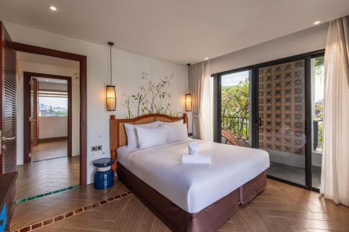 ダナンにあるNatalie Boutique Hotel Da Nangの大きなベッドとバルコニーのある寝室