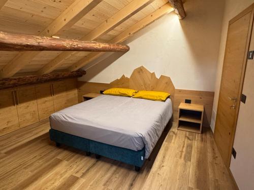a bedroom with a bed in a room with wooden ceilings at Caluma El Paradis in Comune Rivamonte Agordino