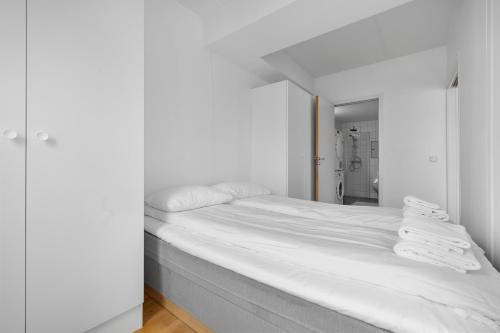 a white bed in a room with a mirror at Centrally located apartment in Tromsø in Tromsø