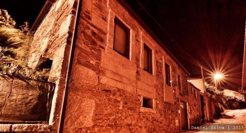 a brick building with windows on a street at night at Casa do Páteo in Macieira de Alcoba