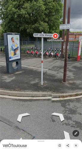 a sign on the side of a street with bikes parked at Chambre cosy à Toulouse proche de Rangueil in Toulouse