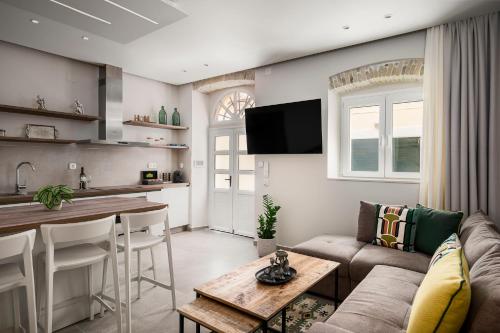 a living room with a couch and a table at Petite Apartments by Konnect, Old Corfu Town in Corfu Town