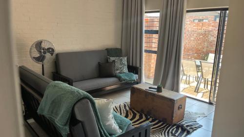 a living room with a couch and a fan at MiCasa 62 in Potchefstroom