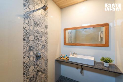 un baño con lavabo y espejo en StayVista at Thalassa Near The Beach, en Alibaug