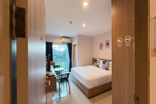 a bedroom with a bed and a desk and a table at SKM Paradise Mae Sai in Mae Sai