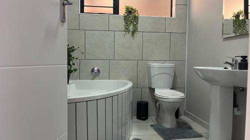 a bathroom with a tub and a toilet and a sink at MiCasa 62 in Potchefstroom