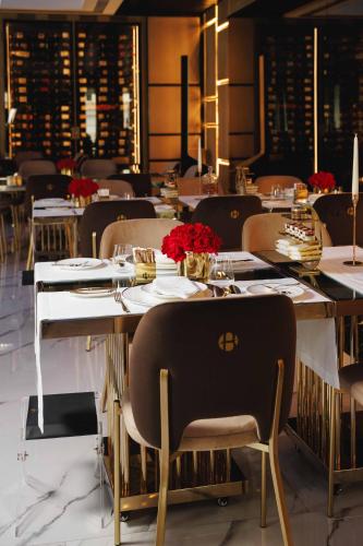 una sala da pranzo con un tavolo con sopra dei fiori rossi di Bra Hotel a Bari