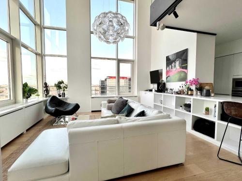 a living room with a white couch and a chandelier at Skyline Penthouse Brussels 220 m2 of Pure Luxury Suite in Brussels