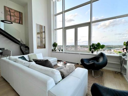a living room with a white couch and a large window at Skyline Penthouse Brussels 220 m2 of Pure Luxury Suite in Brussels