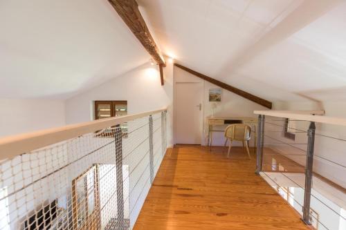 un couloir mansardé avec un escalier et une table dans l'établissement Gite du platane, à Bélis