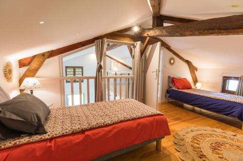 une chambre avec deux lits et une grande fenêtre dans l'établissement Gite du platane, à Bélis