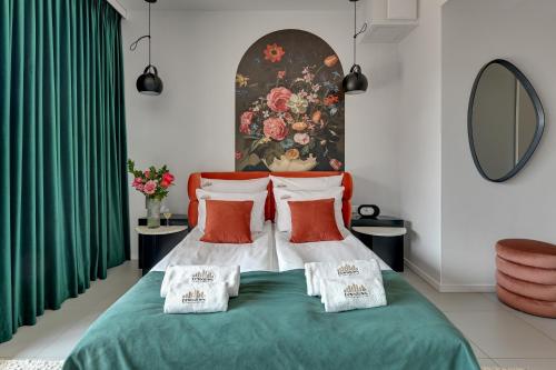 a bedroom with a bed with green sheets and red pillows at DEO PLAZA Apartments & Riverside by Downtown Apartments in Gdańsk