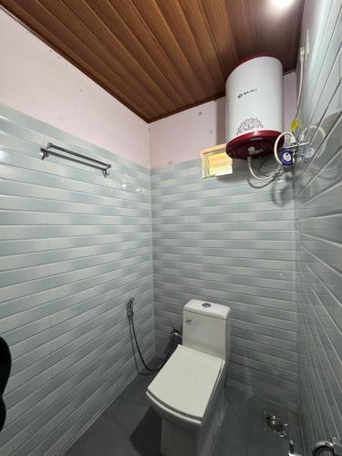 een badkamer met een wit toilet in een kamer bij River stream Nest homestay in Madikeri