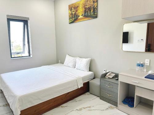 a bedroom with a bed and a desk and a mirror at Anh Thư Hotel in Ấp Bình Hưng